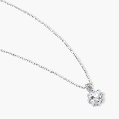 Platinum-plated sterling silver necklace with round clear crystal pendant and decorative bail on neutral background.